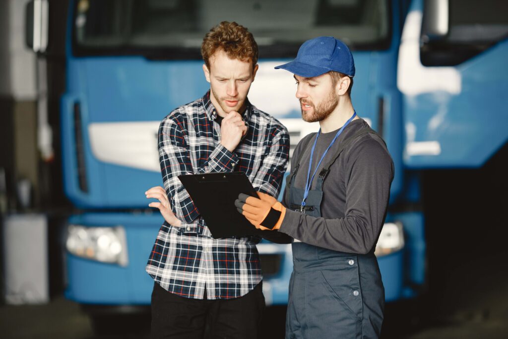 Two young men discuss work issues in garage